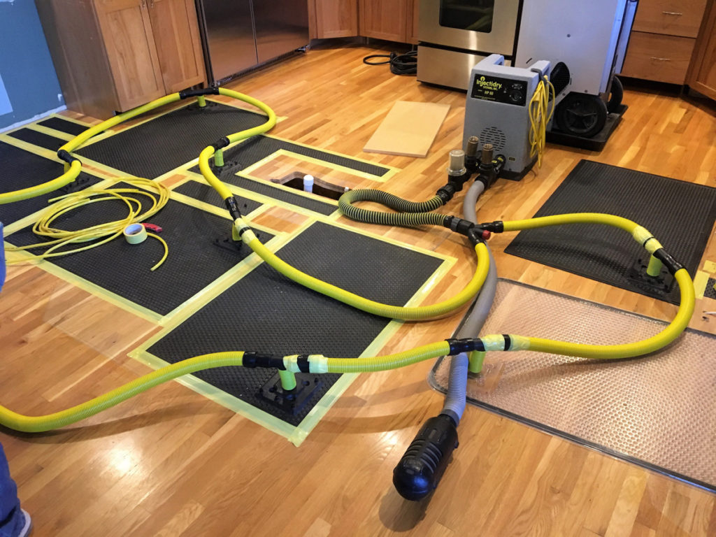 Professional drying equipment set up on a wooden floor during restoration
