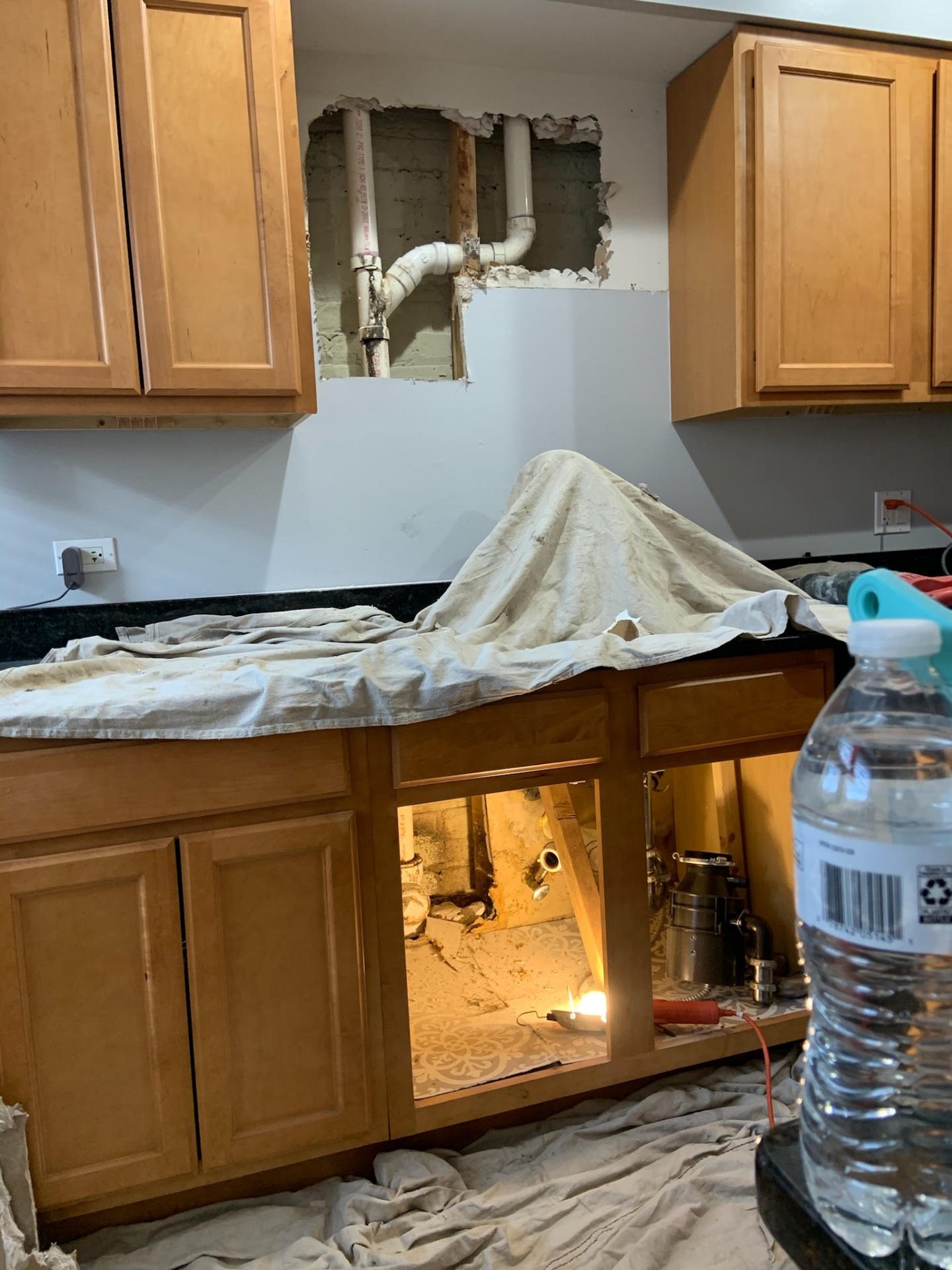 Kitchen water damage caused by a burst pipe behind the cabinets